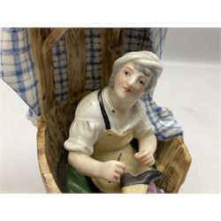 Pair of Continental figures in the Meissen style, modelled as a shoemaker and a laundress seated within wooden barrels with gingham cloth draped behind, H20cm