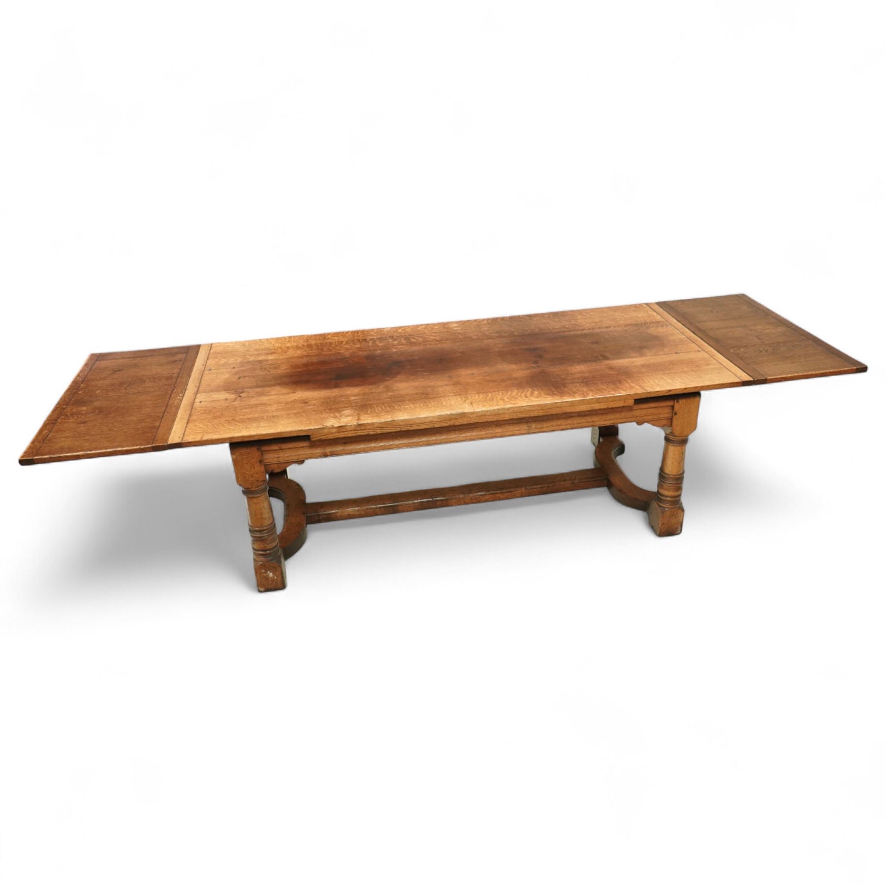 17th century design oak refectory extending dining table, the rectangular planked top with cleated ends, with two concealed leaves, raised on turned baluster supports united by shaped stretchers (Extends to 331cm)