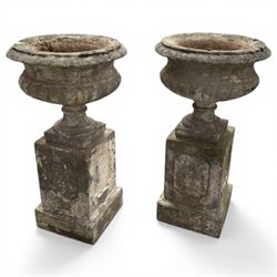 Pair of 20th century cast stone urns on plinths 