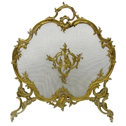  French Rococo style gilt metal fire screen, cartouche shaped ornate scrolling frame and supports, the mesh panel applied with a seated cherub, W62cm x H71cm   