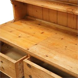 Traditional pine kitchen dresser, the open rack with three shelves beneath a moulded top, over a base fitted with two drawers and a pair of panelled cupboard doors, the whole raised on a moulded base