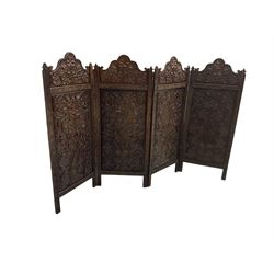 Burmese carved hardwood folding screen, four shaped arch panels profusely carved with foliage 
