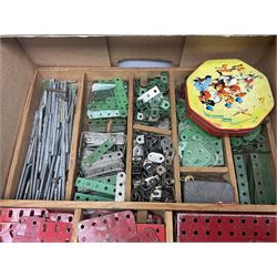Meccano - large quantity of loose parts including various plates and strips, flanged plates, pulleys, axle rods and crank handles, wheels and tyres, gear wheels, brackets, nuts & bolts, various manuals; predominantly red and green; some in compartmentalised wooden trays