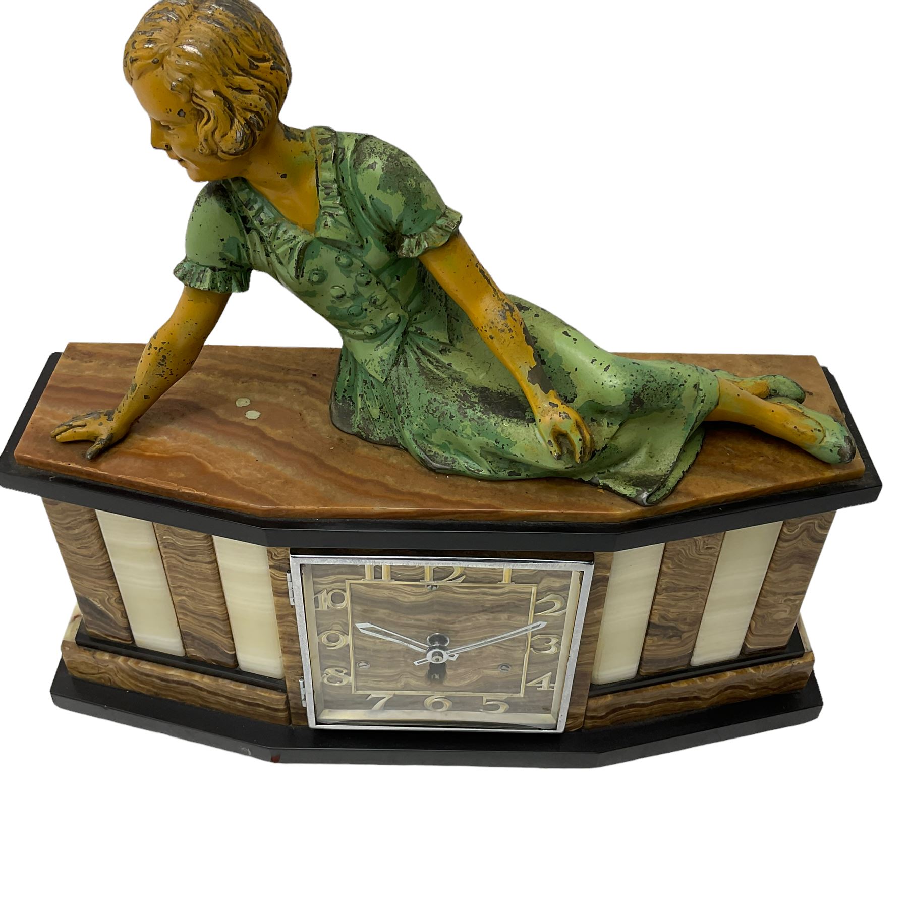 A 1950's Art Deco mantle clock in contrasting black, white and brown onyx marble, surmounted by a reclining spelter figure of a young lady, with a 6” square dial with a chrome bezel, Arabic numerals and chrome baton hands, with a timepiece spring driven movement.  With pendulum.

