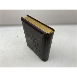Victorian leather bound photo album, the interior leaves containing apertures of various sizes and shapes of portraits surrounded by printed floral designs, H28cm