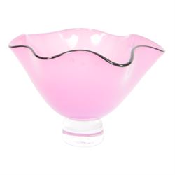 Gillies Jones pink glass bowl with crimped black rim upon a pedestal foot, H11cm