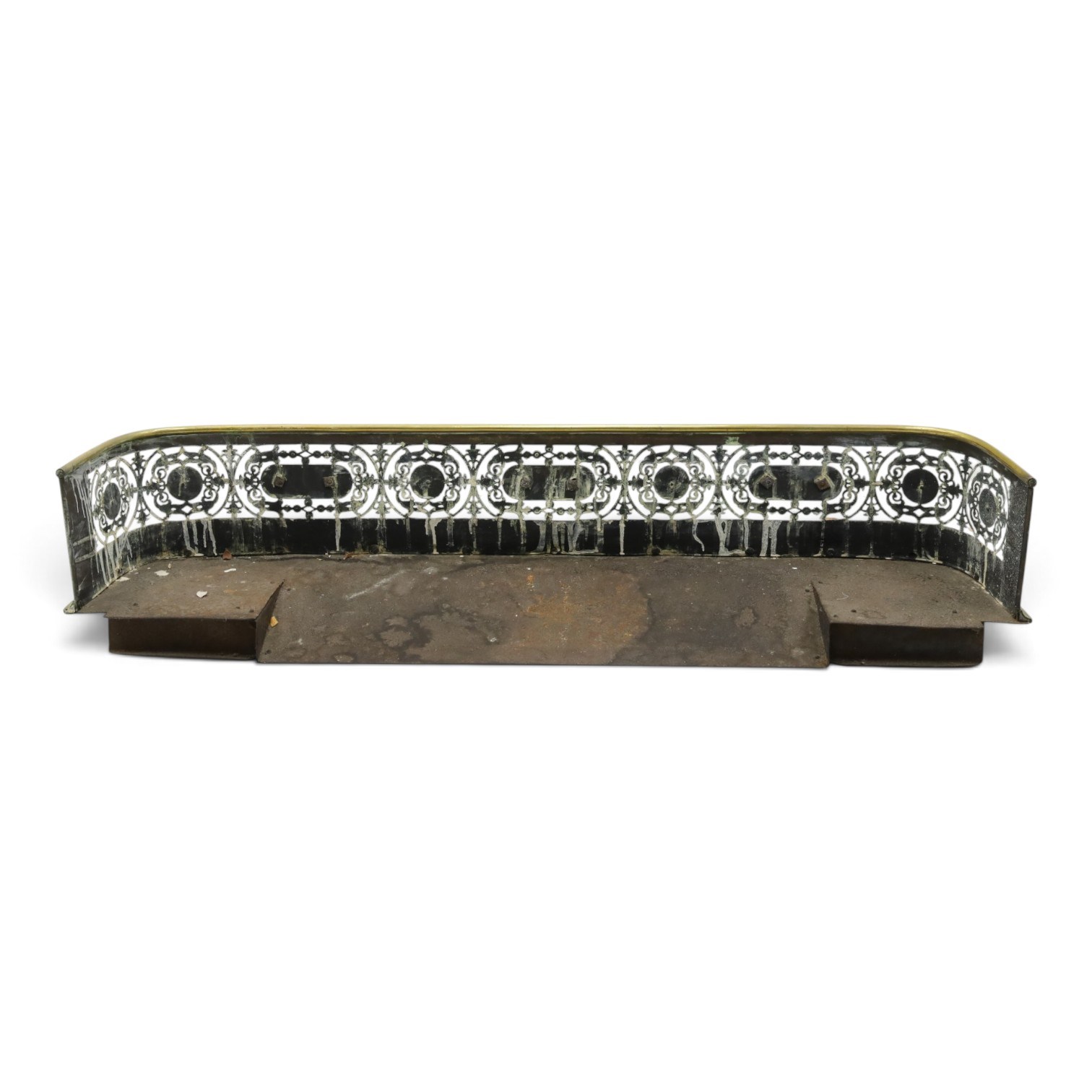 Victorian pierced brass fire fender, the pierced scrolling gallery of Aesthetic taste with applied roundels and protruding lobed mounts, raised on bun feet