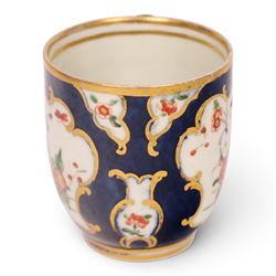 18th century Worcester coffee cup and saucer, circa 1770,  painted with shaped panels of chrysanthemums and banded hedges on a blue scale ground with gilt detail to the rim, mark beneath, H8cm 