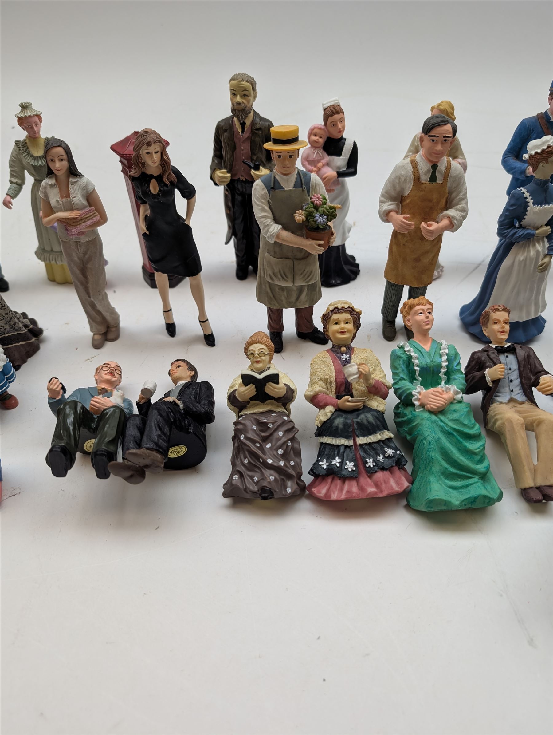 1:12 scale dolls house composite figures, including policeman, postman, maid, sitting and standing people in various styles of dress, etc