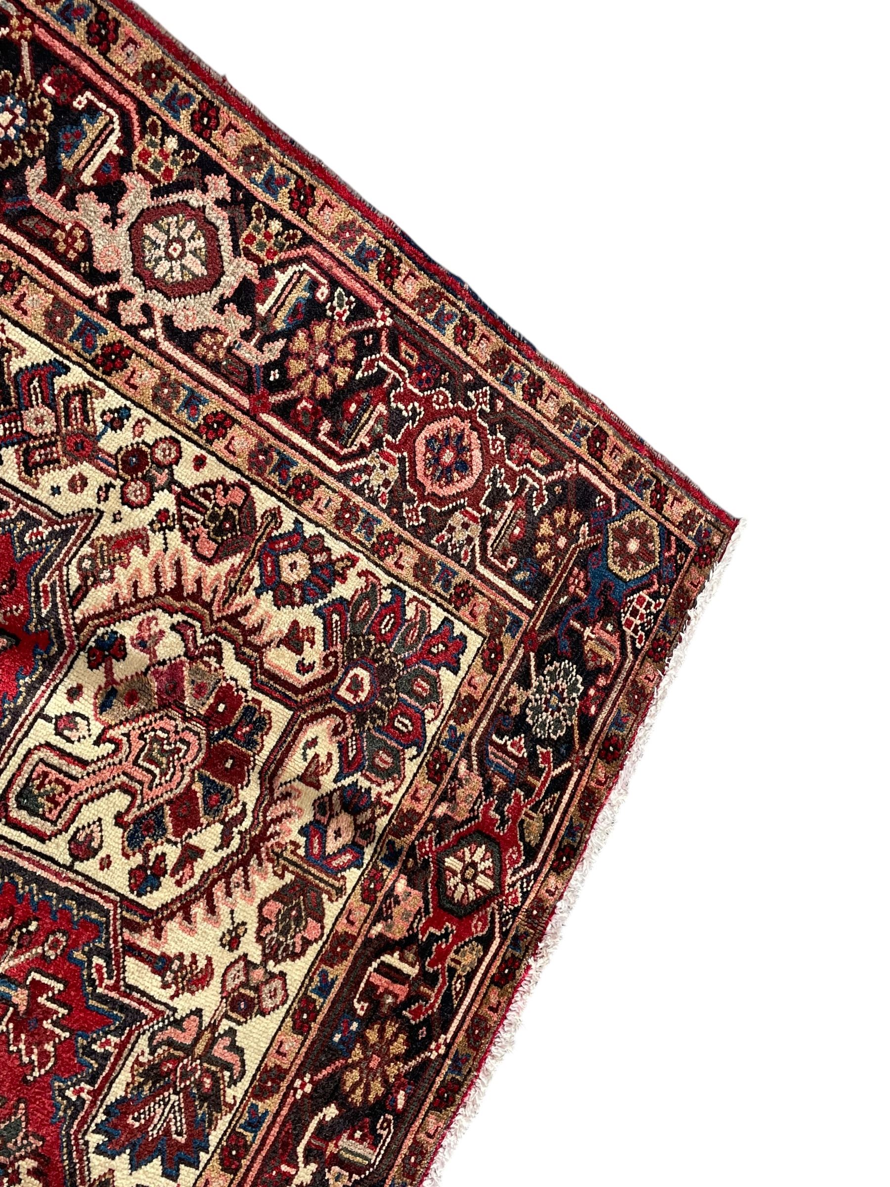 Persian Heriz red ground rug, large medallion decorated with palmettes and Ejder motifs, the border decorated with stylised plant motifs, within floral design guard stripes 