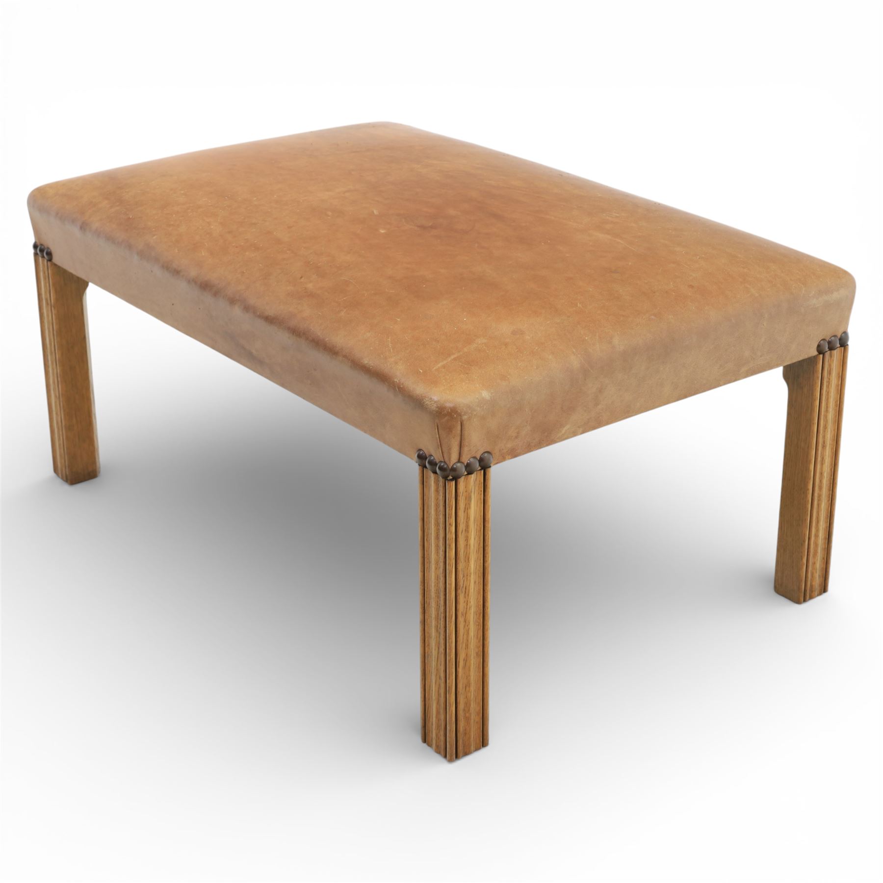 Modern tan leather stool, with studded detailing above a reeded stile supports terminating in metal caps