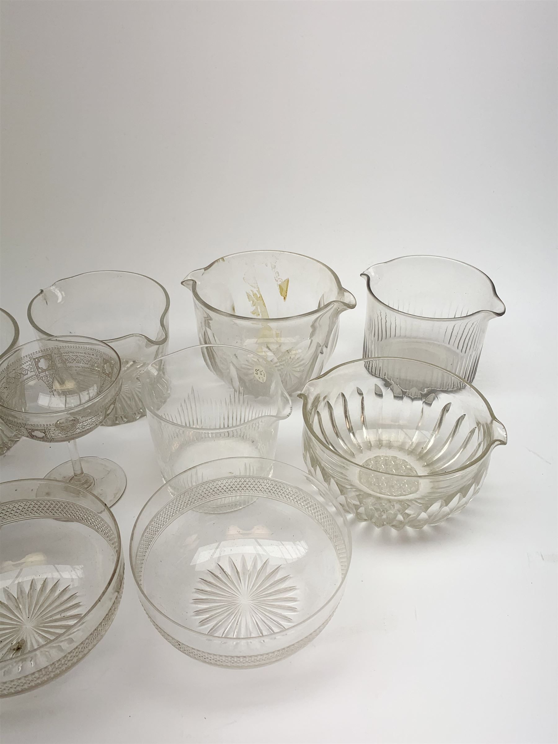 Seven 19th century and later double lip glass rinsers of various design, together with a pair of Edwardian cut glass finger bowls, and four Edwardian champagne glasses with engraved decoration. 