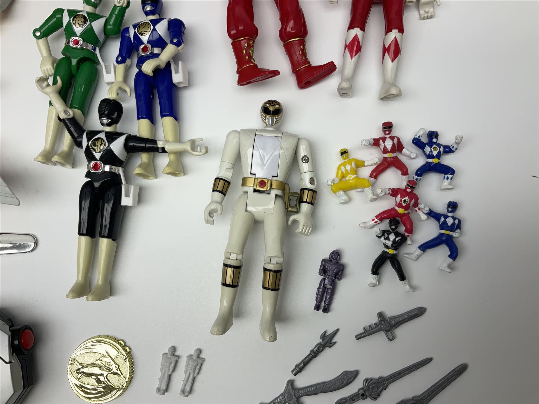 Collection of early 90s Mighty Morphin’ Power Rangers Zords, figures and accessories. Titanus the Carrier Zord, marked Bandai 1991; Green Dragonzord, incomplete; 1994 White Tigerzord with original instruction manual; 1993 Triceratops Dinozord, Mastodon Dinozord and Sabertooth Tiger Dinozord, Pterodactyl Dinozord, missing guns; with 1993 Power Morpher and original Power Coins, with further related figures, accessories and weapons