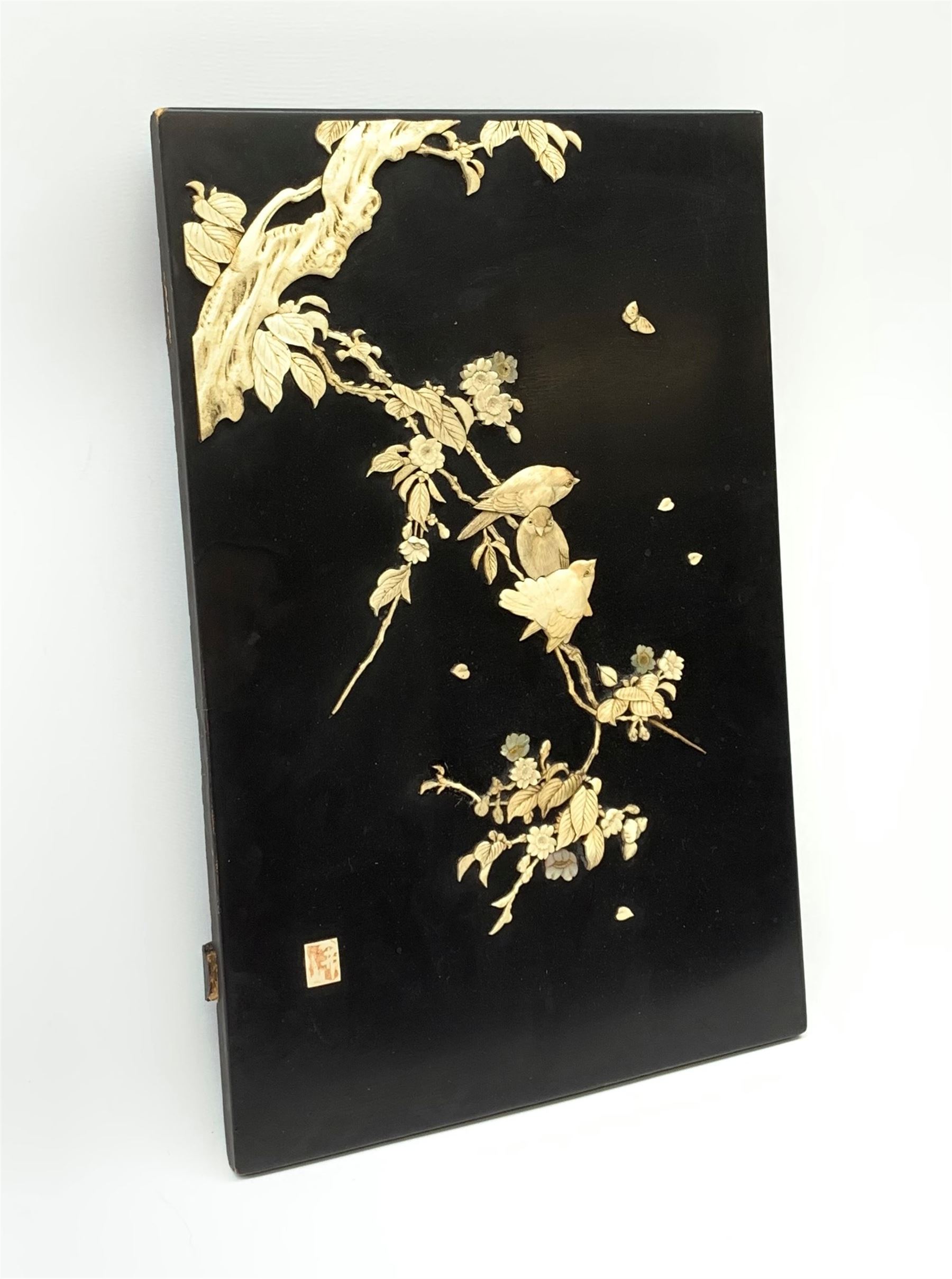 An early 20th century Japanese Shibayama panel, depicting three birds seated upon a blossoming branch in ivory and mother of pearl, with applied ivory character mark panel lower left, H45.5cm L30cm. 