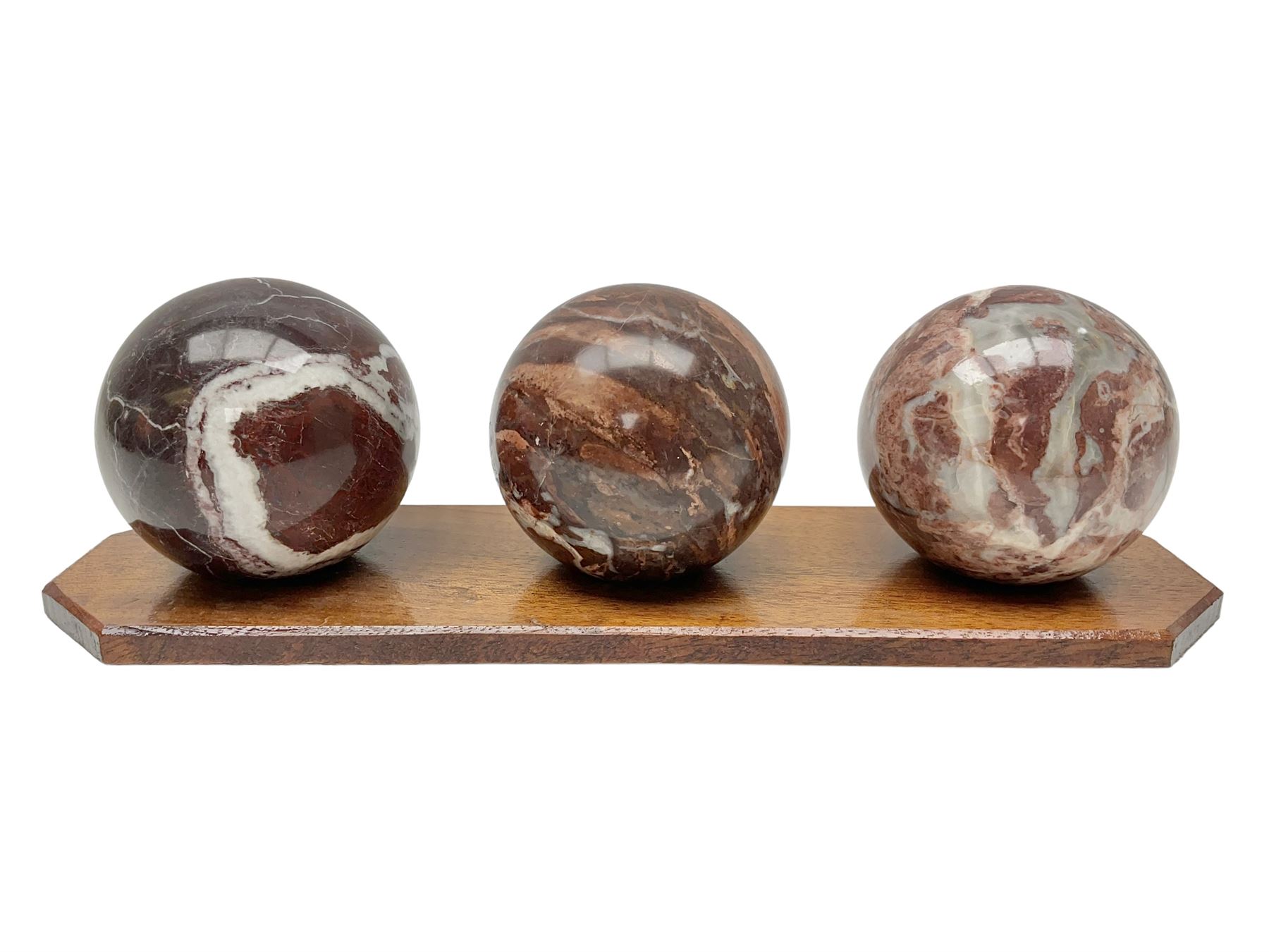 Set of three marble spheres on a elongated octagonal wooden base, H12cm
