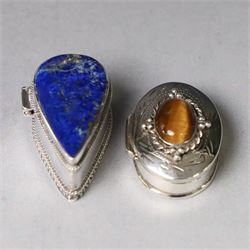 Two modern silver pill boxes, the first example of oval form, the hinged cover set with a ...