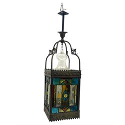 20th century Gothic design stained glass and brass hall lantern, with ornately decorated frieze and apron, with geometric coloured glass panels and eight rectangular bevelled glass panels, with bell shade, wired for electricity 