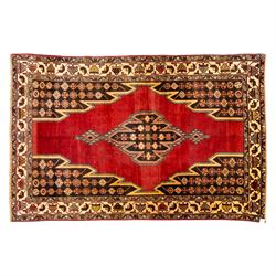 West Persian Mazlaghan hand-knotted rug, madder red field with central stepped lozenge med...