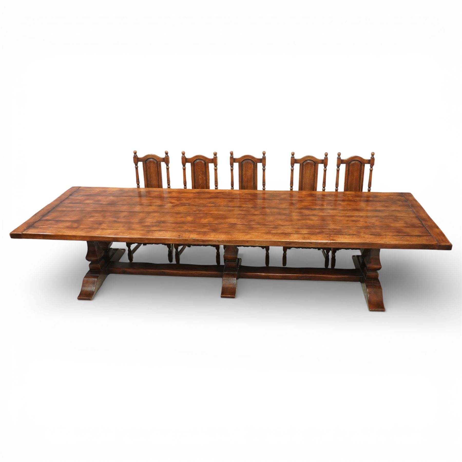 Country House 12' oak and fruitwood refectory dining table, the substantial rectangular plank top with cleated ends and chamfered edge, raised on twin trestle end square tapering and turned baluster supports with sledge feet and chamfered united by a long stretcher rail