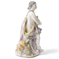 18th century possibly Staffordshire porcelain figure of Vulcan, adorned in classically draped robes, holding an urn and standing on a naturalistic base with volcanic flames H20cm