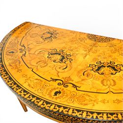 20th-Century Louis XVI-Style satinwood and penwork circular table or pair of console tables, the circular quarter-veneered top decorated in penwork with a central classical mask head motif within scrolling foliate and anthemion ornament on a contrasting black ground, above a conforming frieze decorated with Greek key-type scrolls. Raised on square tapering legs, each with an upper block panel decorated with compass-star motifs.