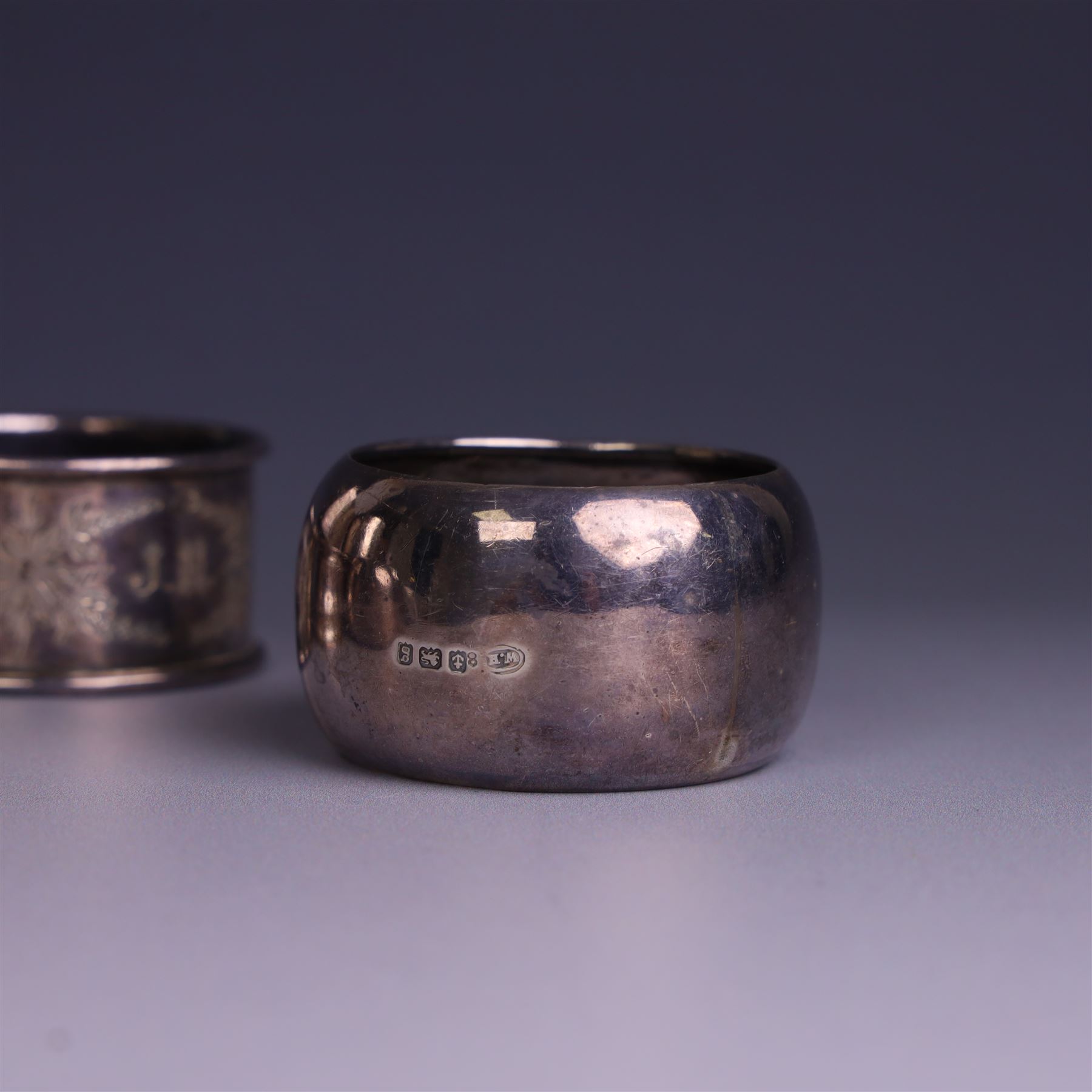 Seven silver napkin rings, of varying design and each with engraved initials, all hallmarked