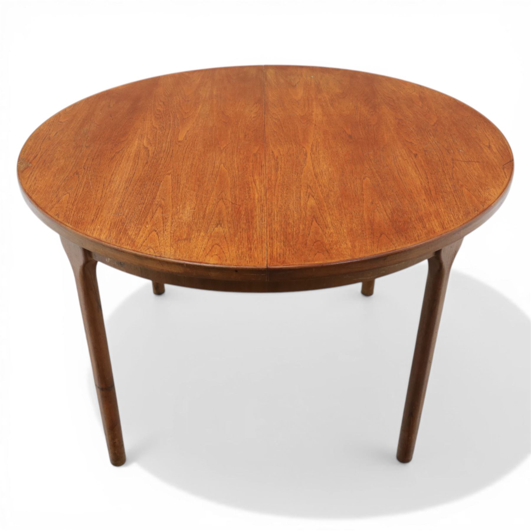 A H McIntosh & Co of Kirkcaldy - teak circular top with moulded edge enclosing butterfly leaf extension, raised on four tapering supports, extending action revealing central leaf, 167cm fully extended