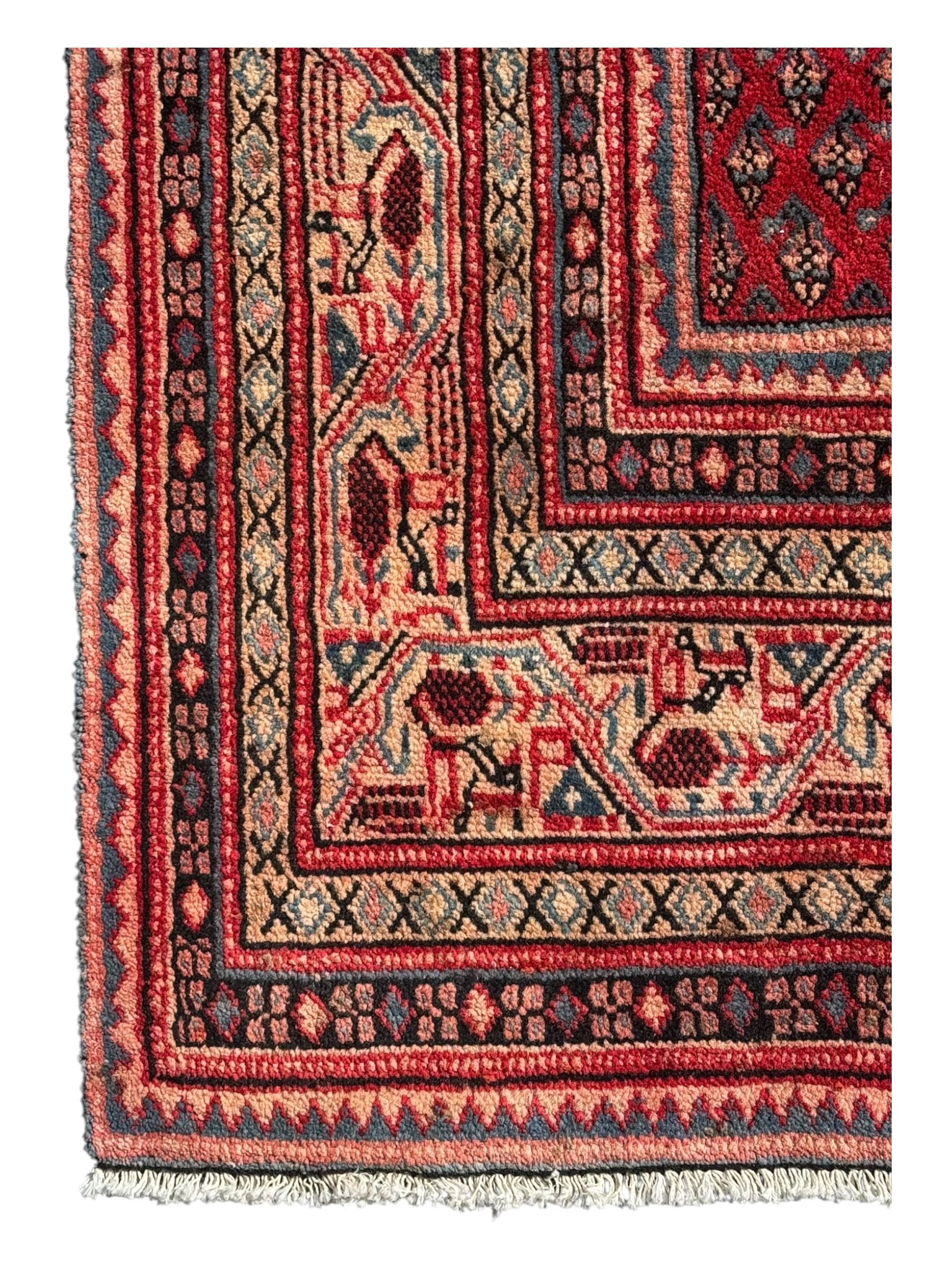 Persian Arak crimson ground rug, the field decorated with repeating Boteh motifs within geometric guard stripes