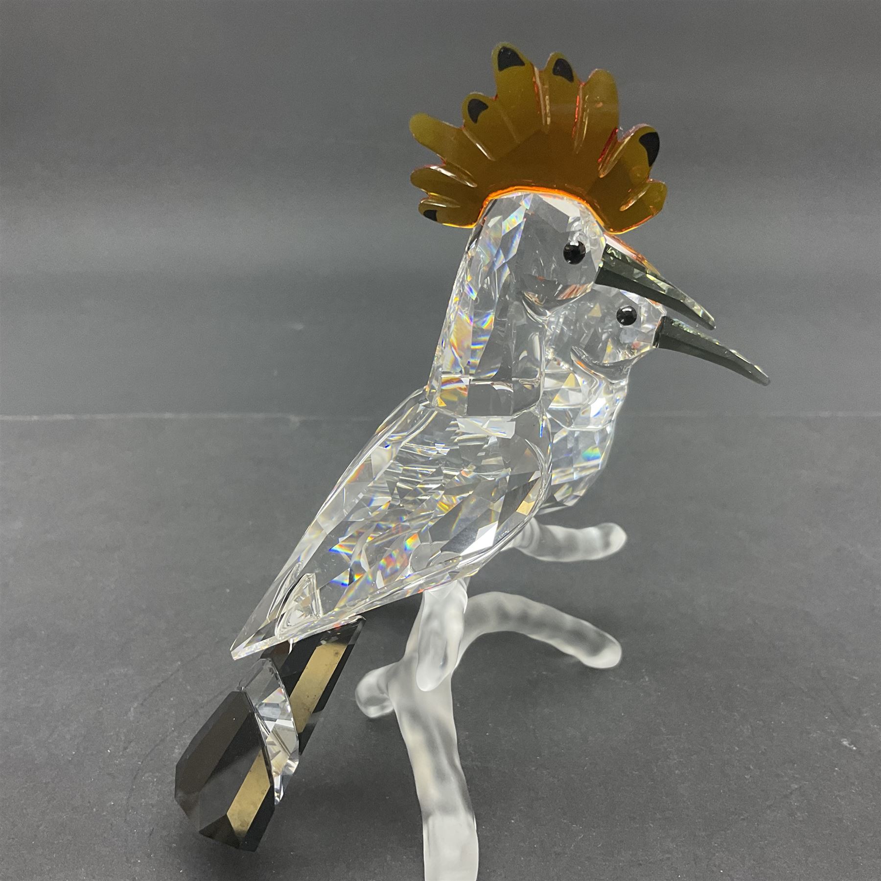 Four Swarovski Crystal bird figures, comprising Cockatoo, pair of Hoopoes on a branch, four Lovebirds on a branch and four Hummingbirds on a branch, largest H10cm