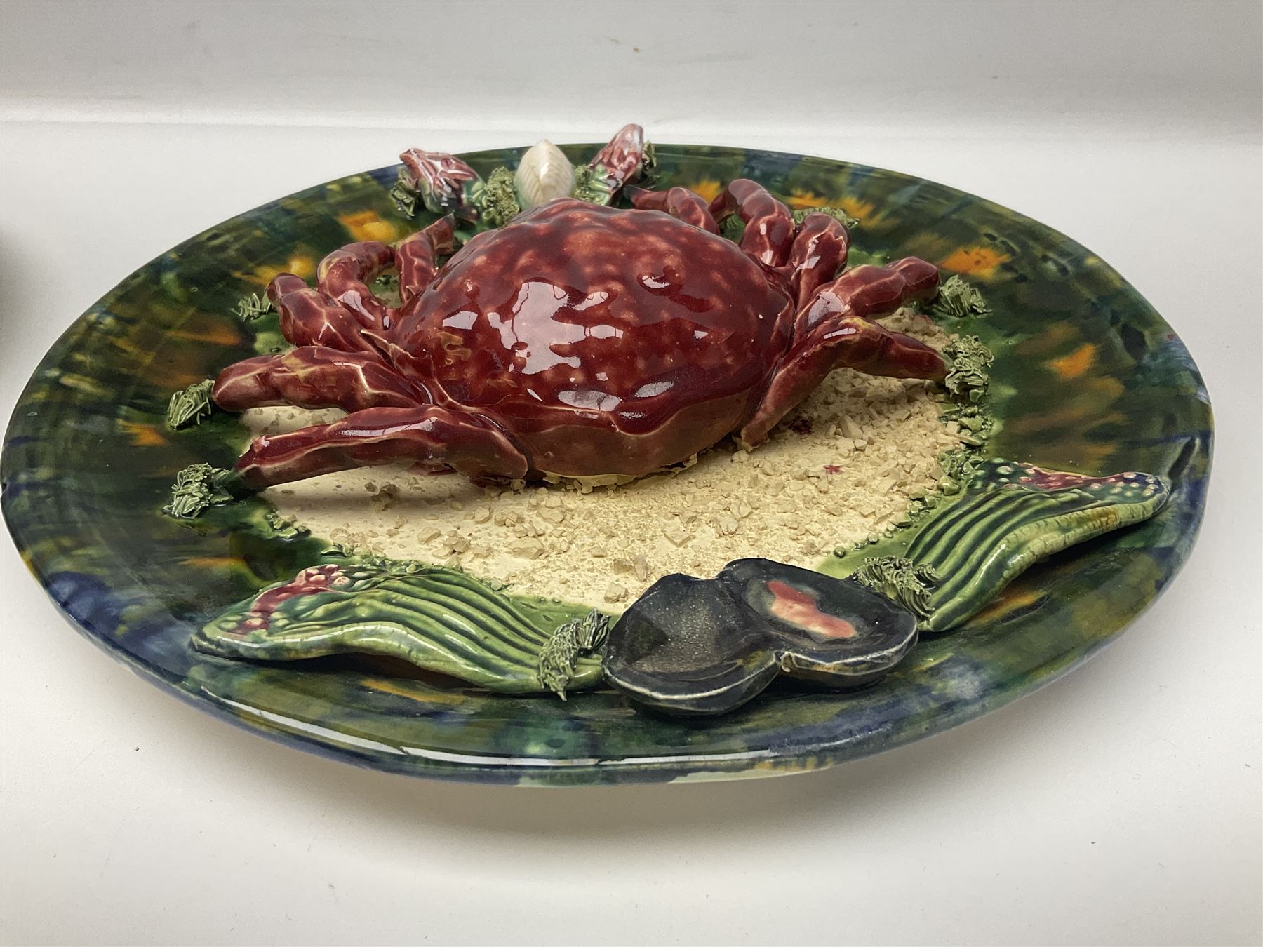 Two 20th Century Portuguese Palissy style Majolica wall plates, one depicting a crab, the other a lobster each to the centre modelled in relief surrounded by encrustations and shells, both with impress marks beneath, D32cm