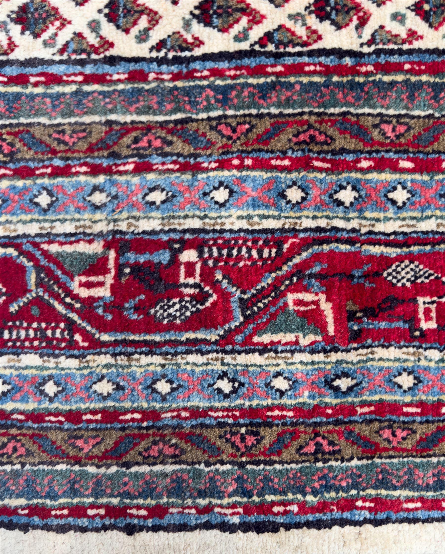 Northwestern Persian Bottehmir hand-knotted rug, ivory field with an all-over design of boteh motifs arranged in diagonal rows within multiple borders and a primary madder red field with stylized vine and flowerhead motifs, 320cm x 214cm 