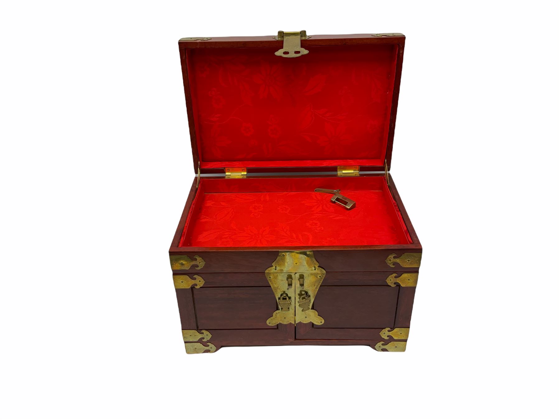 Chinese hardwood jewellery box mounted with engraved brass fixtures, the two exterior doors revealing three drawers below the hinged upper lid, lined with red material decorated with floral sprays, H25cm, W36cm, D23cm