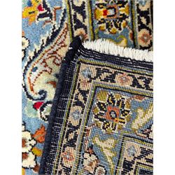 Persian Kashan indigo ground carpet, floral pattern light blue ground central medallion and spandrels, the fielding decorated with interlacing leafy branches and palmettes, the repeating floral pattern border enclosed within guard stripes