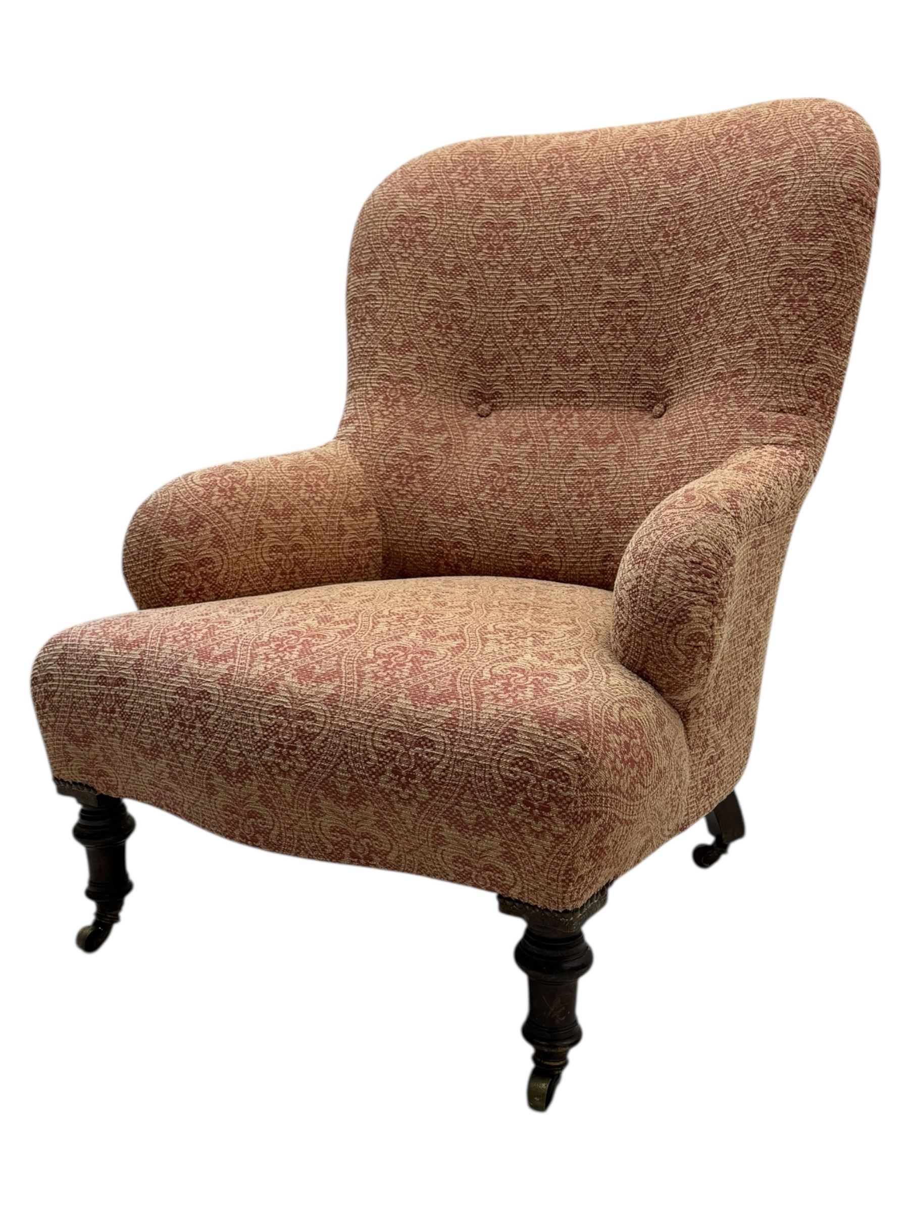 Late Victorian upholstered armchair, with high camel back and deep seat, padded arms and backrest in crimson and cream damask-style fabric, raised on turned ebonised front supports with ceramic castors (H88cm, W65cm, D 60m); and an Edwardian bedroom chair with button upholstered rail back (H72cm, D64cm, W53cm) (2)