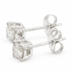 Pair of platinum diamond earrings, each stud four claw set with a single round brilliant cut diamond, stamped Pt 950, total diamond weight approx 0.85 carat