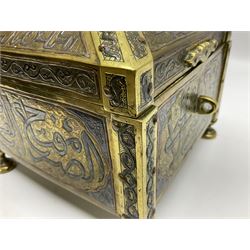 Late 19th century Damascus Cairoware Quran box, of square form with canted hinged cover, upon four circular pad feet, the brass exterior inlaid with silver and copper script and decorative detail, opening to reveal a marquetry lined interior, H15.5cm W19cm D19cm