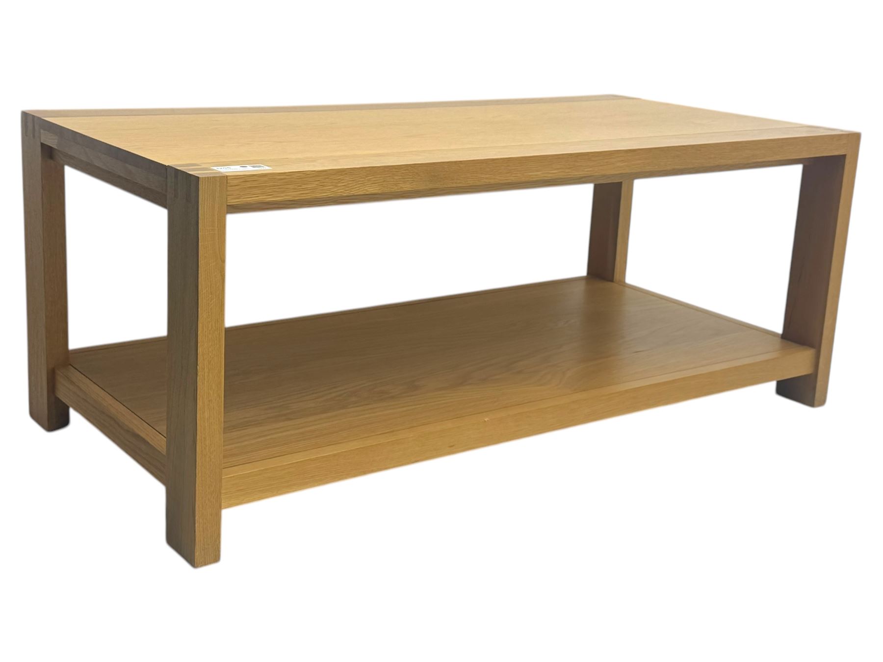 Light oak rectangular coffee table, with exposed finger joints to the corners, raised above a full-length undertier on straight supports