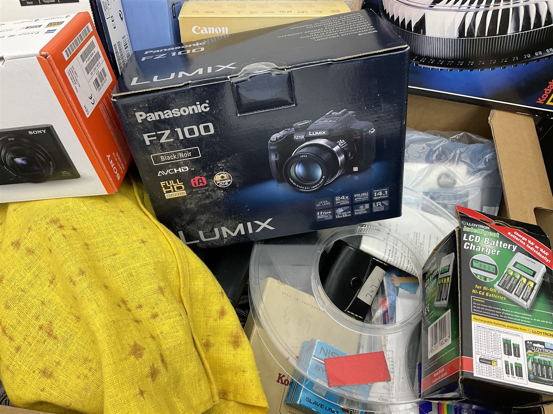 Large quantity of camera equipment in three boxes - Lumix GX1 camera, Canon EOS 500 camera, Lumix FZ100 camera, Pantax  MZ5n, various other cameras, Swift spotting Scope 20 x 60 in box,  Maxtor hard drive, three tripods, Kodak carousel projector, Pradolux slide projector, a selection of camera bags and other camera equipment. 