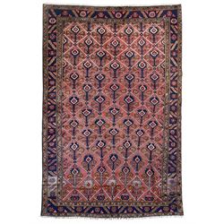 Persian Ardakan crimson ground rug, the field divided by lattice and decorated with stylised tree of life motifs, the border decorated with geometric flower heads, within guard stripes 