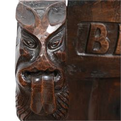 Mouseman - circa. 1920s adzed oak settle or bench, the cresting rail carved with inscription 'Before Honour is Humility', four panel back and plank seat on shaped end supports carved with grotesque masks terminals, carved with mouse signature, by Robert Thompson of Kilburn 
