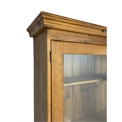 Large pine bookcase on cupboard, the upper section enclosed by two glazed door, the lower section fitted with two drawers and double cupboard, on plinth base