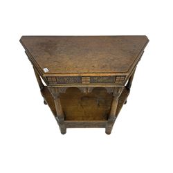 Jacobean design carved oak side or credence table, demi-heptagon top with moulded edge, frieze carved with foliate C-scroll design above ornate arcade carved apron, under-tier united by ring turned pilisters, lower frieze carved with repeating lunettes