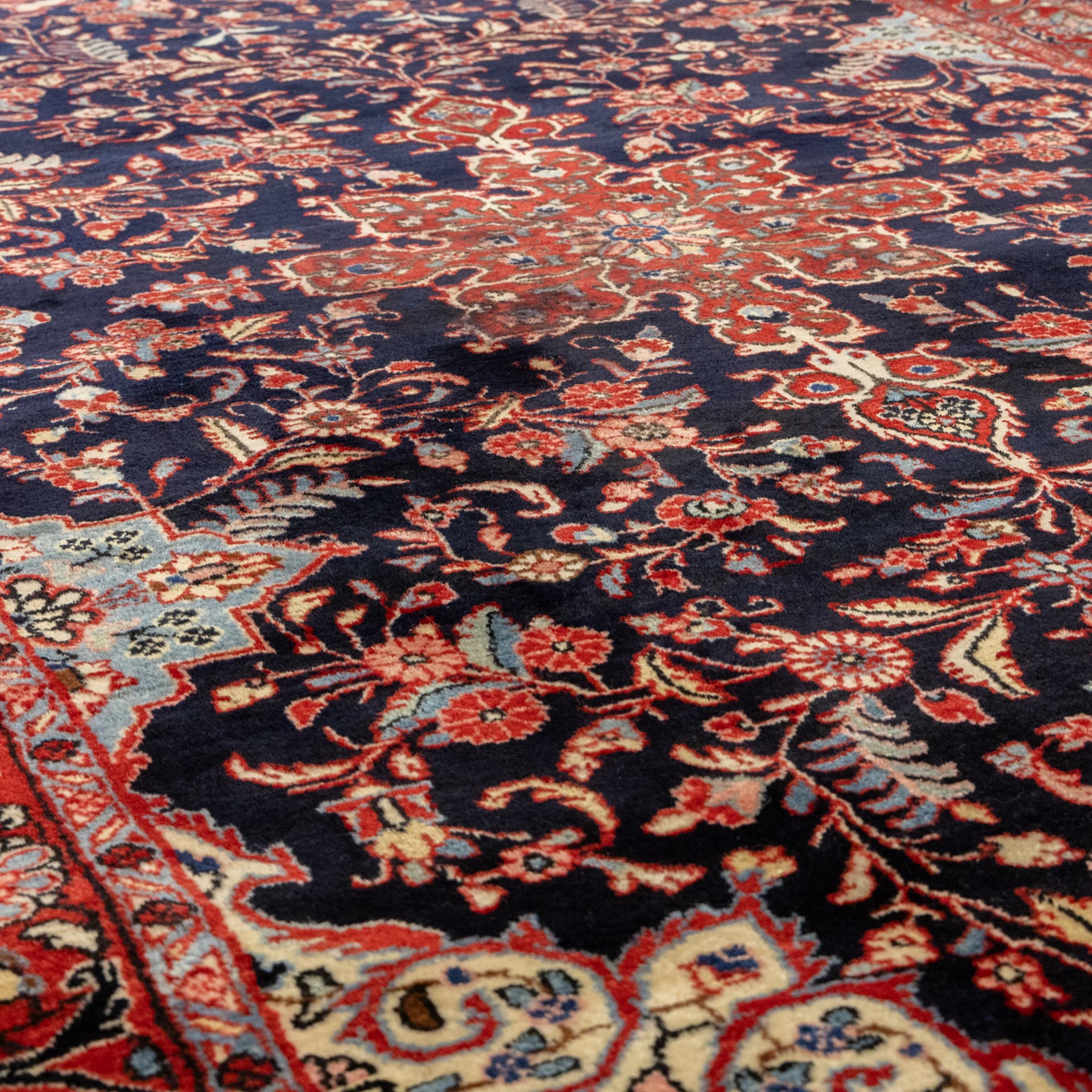 Two hand-knotted rugs, comprising Persian floral rug, dark blue ground decorated with scrolling foliage and flowerheads within a red floral border (H 208cm, W 134cm); Bokhara type rug, red ground with repeating gul motifs and geometric guard borders (H 174cm, W 94cm)