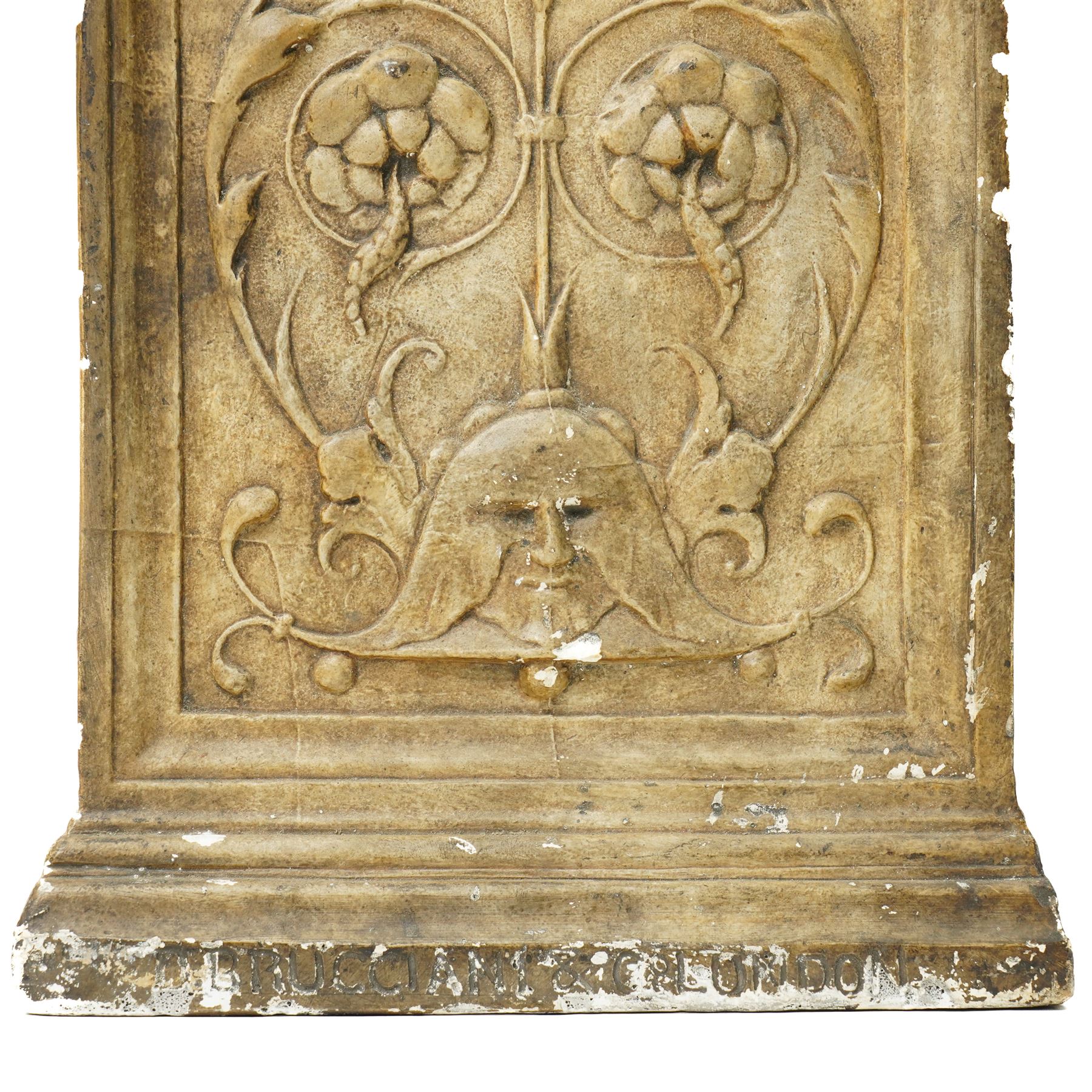 D Brucciani, London - After the antique -  A relief moulded plaster panel No2538 with stylised trailing leaves, flower heads and a mask 62cm x 22cm