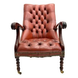 Regency style library chair, upholstered in deeply buttoned red leather, scrolling and moulded arms, on turned front supports with brass castors, studded detail