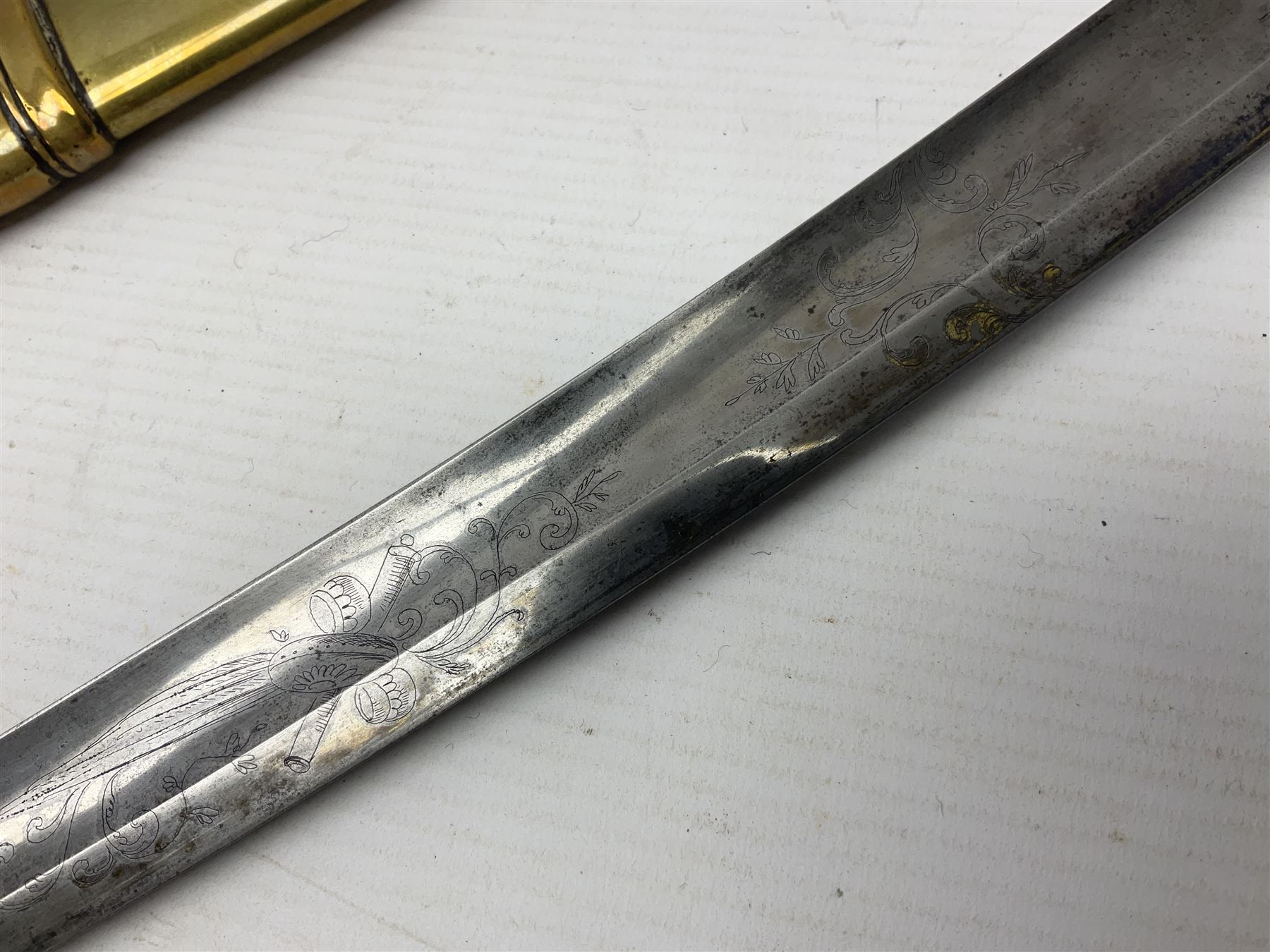 German Saxon 1st Empire Light Cavalry officer's sword c1820s, the 79cm clipped curving blade engraved with the crest of Hanover and various battle trophies with traces of blueing and gilding, brass hilt with knucklebow, foliate square langets, ornate downswept quillon, wire-bound fish skin grip with lion's head pommel; in brass scabbard with two suspension rings L95cm overall