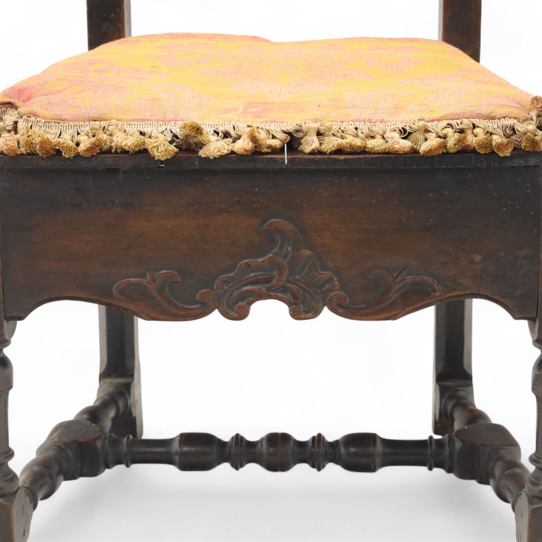 18th century oak provincial armchair, arched and carved cresting rail above triple splat back, shaped arms on turned supports, stuff-over seat upholstered in damask fabric, carved front frieze on turned legs united by stretchers