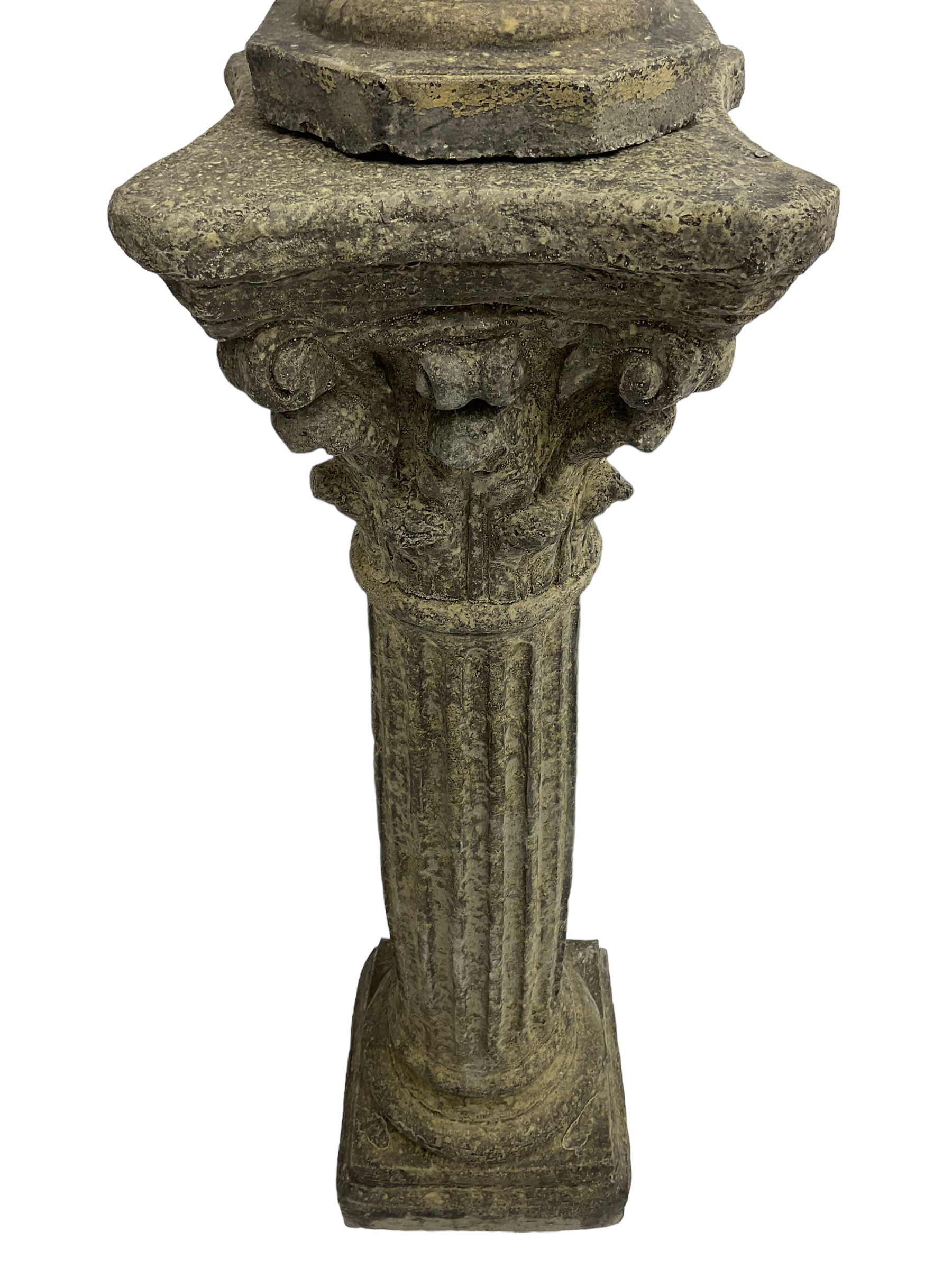 Classical design cast stone female bust depicting Artemis, raised on fluted Corinthian column with acanthus leaf capital, stepped square base, looking right 