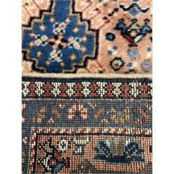 Persian prayer purple ground, decorated with three pointed buildings over tailing lozenge patterned field (111cm x 82cm); and a small Persian rug or mat, overall geometric design (81cm x 56cm)