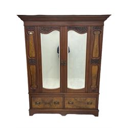 Late 19th century walnut double wardrobe, projecting cornice over two doors carved with scrolled acanthus leaf and fitted with shaped bevelled glass plates, two drawers below, shaped plinth base